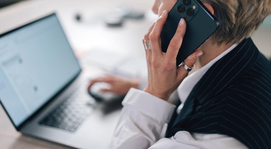 Persona trabajando con documentos financieros y calculadora en escritorio organizado